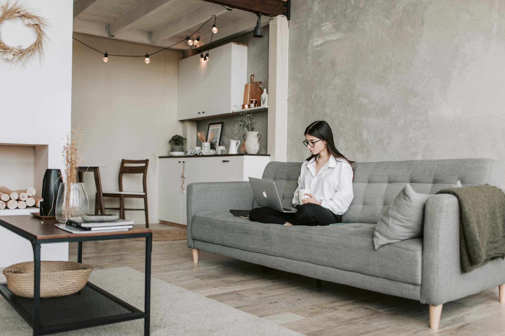 Woman Sitting On A Sofa While Working With Laptop