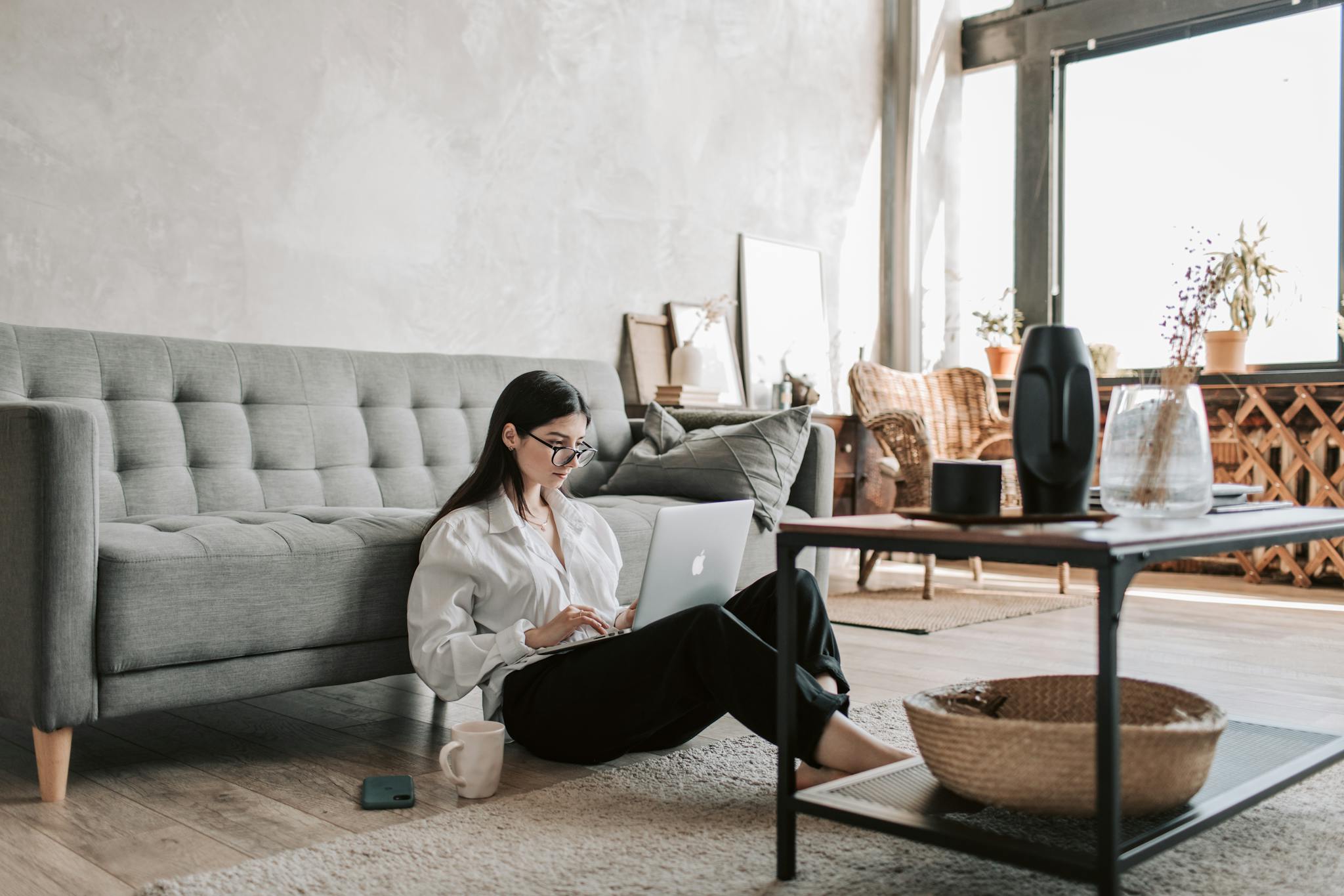 Woman Sitting On The Floor While Using Her Laptop